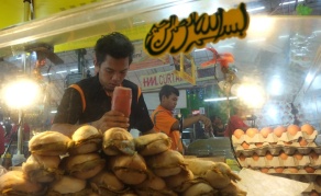Food for thought! A man squeezes ketchup on a local sandwich called roti john